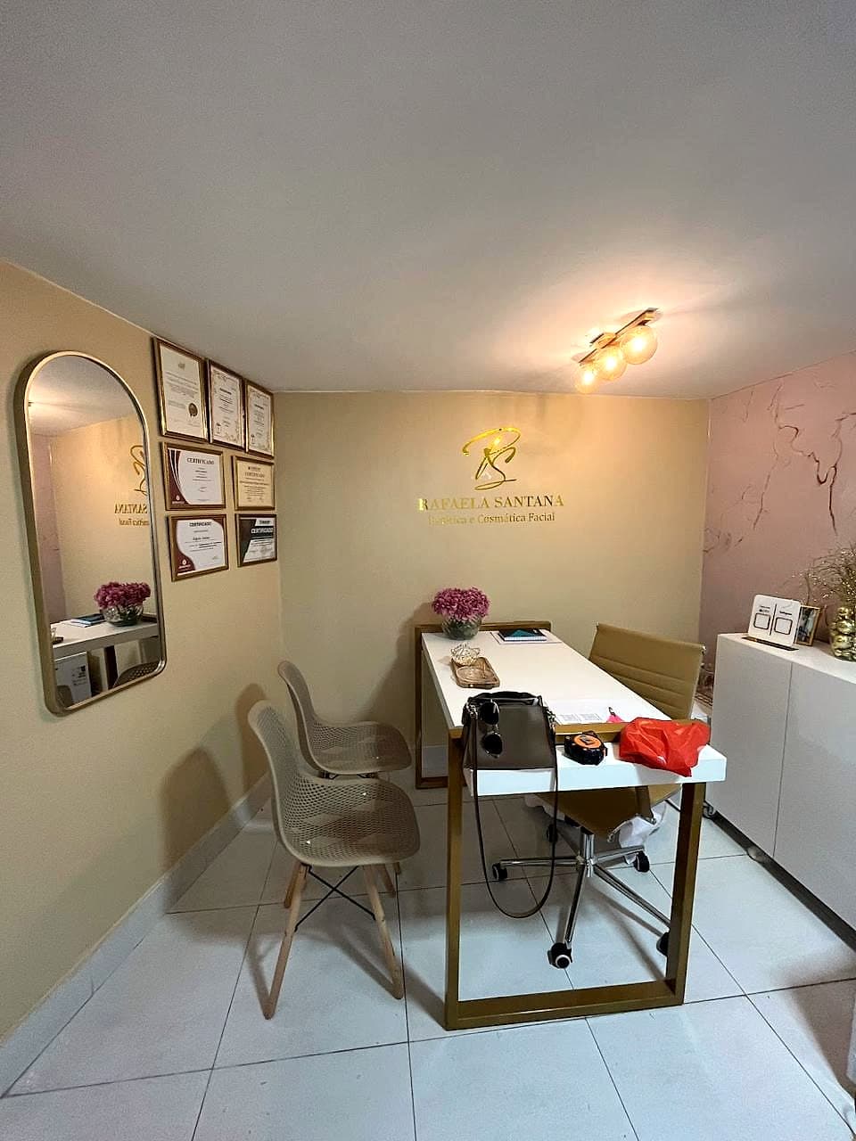 Sala de atendimento da clínica, com certificados e o logo na parede